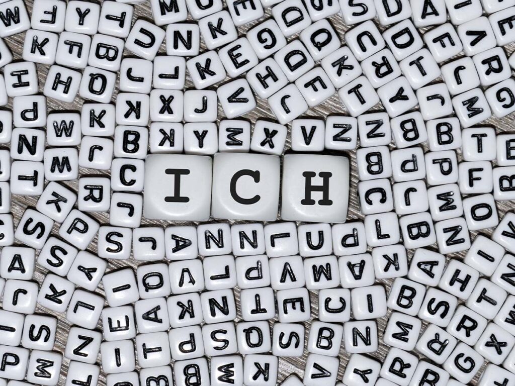 Würfel mit Buchstaben bilden das Wort ICH auf einem Hintergrund aus zufälligen Buchstabenwürfeln. Perfekt für Themen wie Identität.