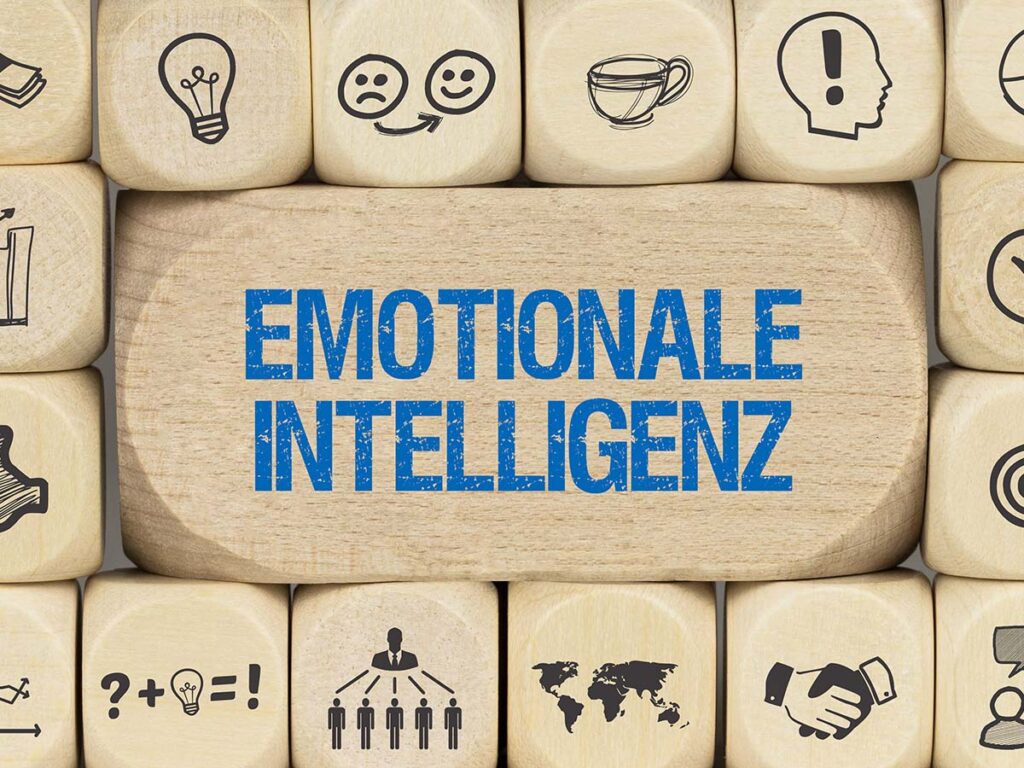 Würfel mit dem Begriff Emotionale Intelligenz. Symbole für Kommunikation und Empathie zur Förderung sozialer Fähigkeiten.