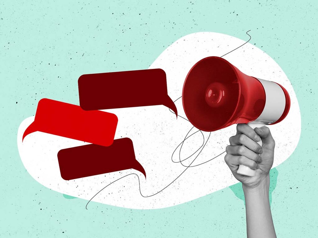 Hand hält rote Lautsprecher mit Sprechblasen, Symbol für Kommunikation und Marketing auf hellblauem Hintergrund.